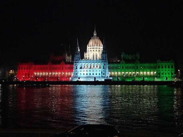 Hungarian Parliament Building at night lighted with the colors of Hungary