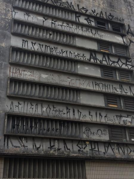 Pixo de São Paulo sur un mur gris, aérations